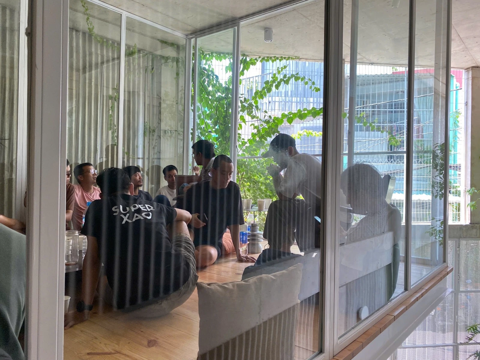 A group conversation seen through the windows of a green building.