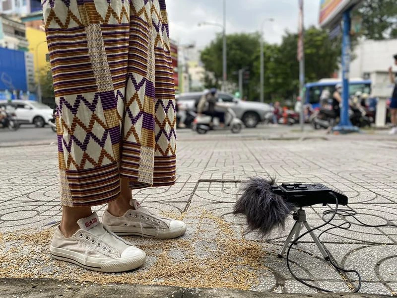 A field recorder on a small tripod beside a participant during a sound walk in Sài Gòn.